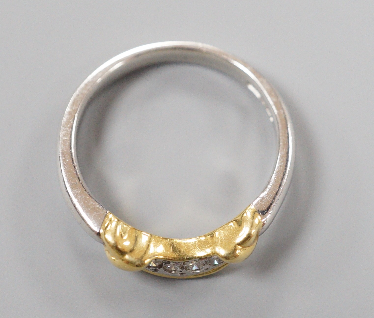 A modern platinum and yellow metal, four stone diamond set demi-lune ring, size N/O, gross weight 5.4 grams (part of a wedding set)